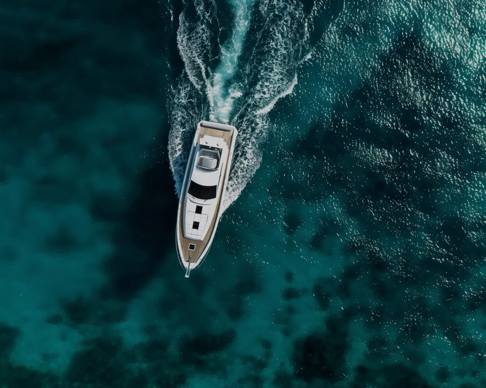 Aerial view of a private yacht charter cruising deep turquoise water — Isabella Yachts, Phuket